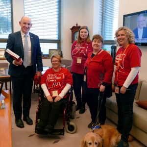Photo inside the office of Minister for the NDIS Stuart Robert at Parliament House. From left to right: Minister Robert; Every Australian Counts Champions Lynne Foreman and Terri Warner; National Disability and Carer Alliance Chair Leah van Poppel and her guide dog Lisa; and EAC Campaign Director Kirsten Deane.