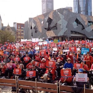 A huge crowd of people with disability, families and workers at Fed Square at the 2012 EAC NDIS Make it Real Rally. Most people are wearing red Every Australian Counts teeshirts