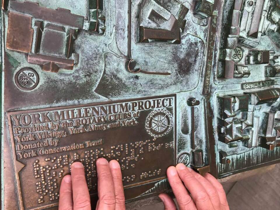 Close up photo of Carleeta's hands touching the tactile map of York, with Braille. 