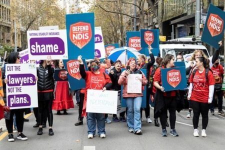 A graphic of Defend our NDIS Activists marching in the street.