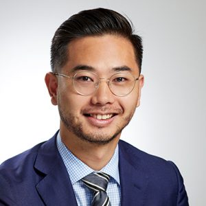 Photo of Chadwick Wong. He is smiling and wearing a blue suit and glasses.