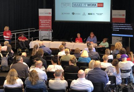 Photo from the back of the room showing the audience and panellists at the Redlands Make it Work forum in 2019.
