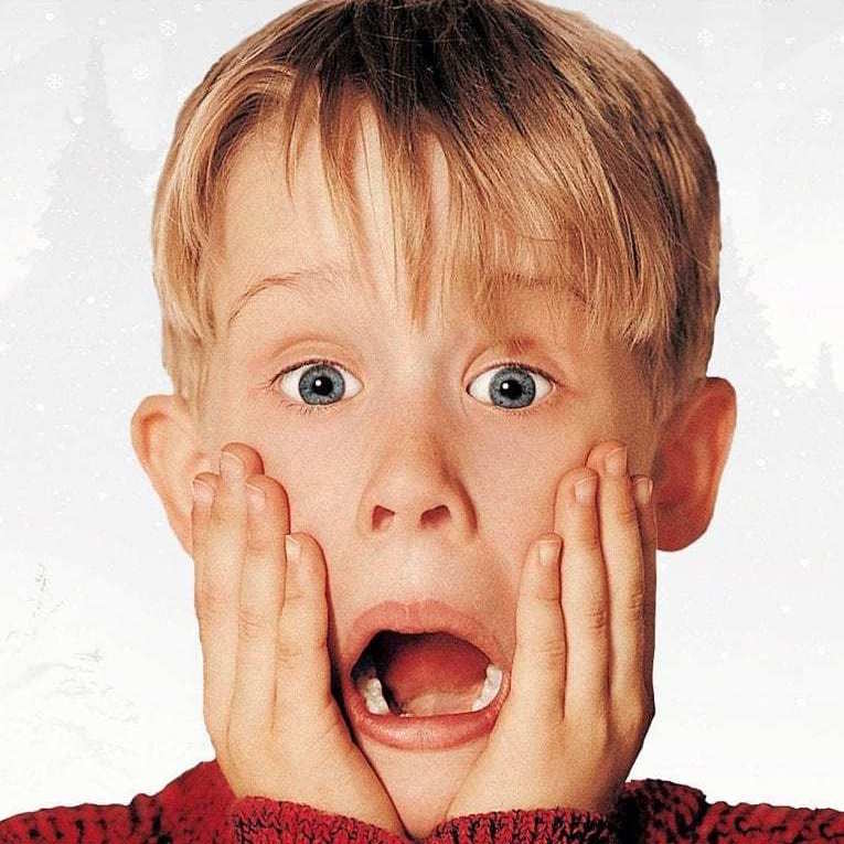 A promotional photo from the 90s christmas movie Home Alone - showing a young boy Search Results Web results Macaulay Culkin with a shocked expression, jaw dropped and hands on his cheeks.