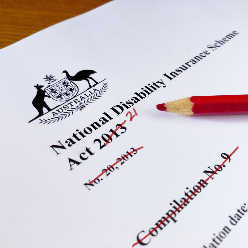 Close up photo of a print out of the NDIS Act. There is a red pencil on top of it. Some words are crossed out. 21 is written next to the crossed out 2013.