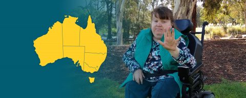 Map of Australia. Woman using an electric wheelchair outside in the bush, holding her hand out as if to motion 'stop'.